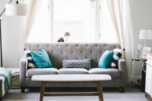 Room with white sofa, white curtains and white table.