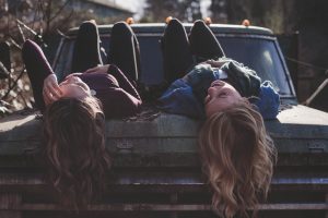 Teens lying on a hood of an old car - it's your job as a parent to help them cope with the move.