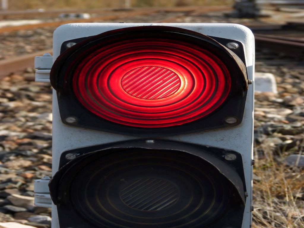 A red traffic light on a railroad.