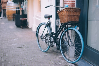A bicycle parked in front of a store in the street.