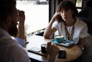 People in coffee shop discussing temporary housing solutions.