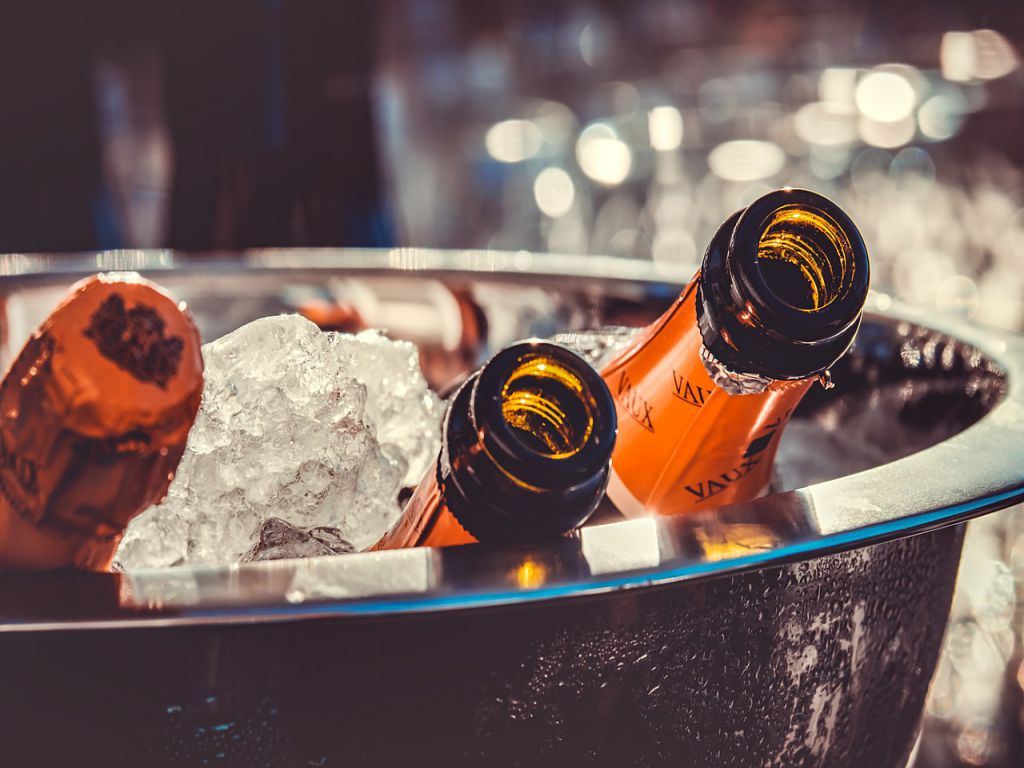 A bucket filled with ice and three bottles of champagne.