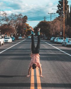 Man doing a handstand in the middle of a road