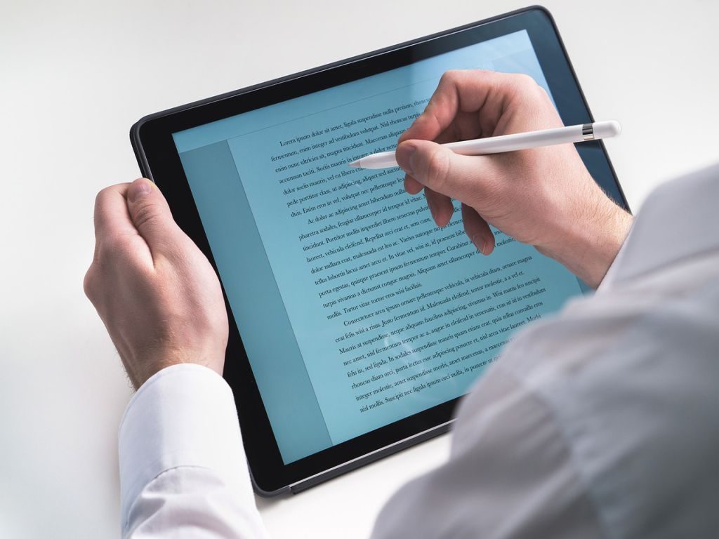 A person going tracing a text on a tablet with a pen.