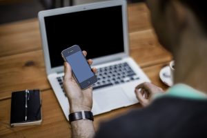 A man holding a phone, calling long distance moving companies Mesa.