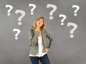 Woman thinking surrounded by question marks