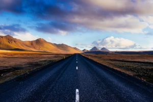 black concrete road with distance to mountains