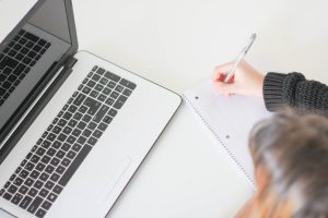 Woman writing a list of things she needs from long distance mvoing companies Orem.