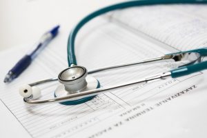 Blue and silver stethoscope on a piece of paper