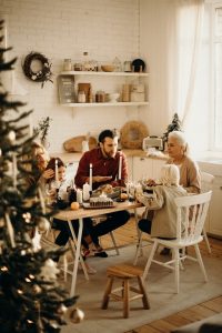 Family siting at a dining table near the Christmas tree