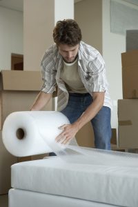 Man wrapping furniture