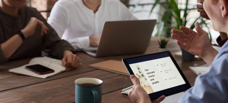 People with tablets and laptops at a desk