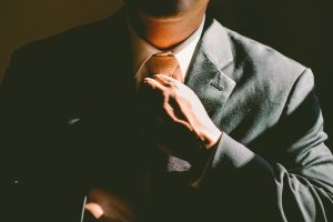 A man in a suit fixing his tie