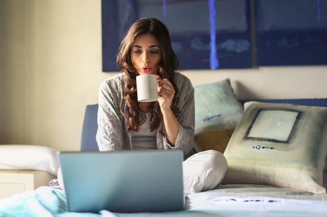Woman working on laptop and drinking coffee