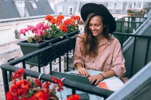 woman working on a laptop on a balcony 