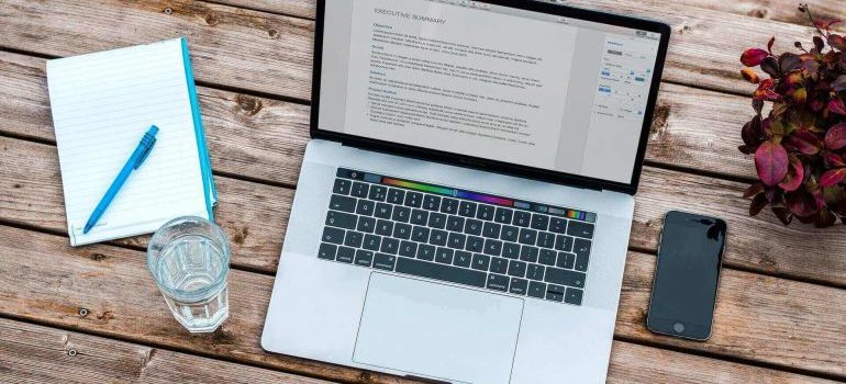 A laptop and a notebook on a desk