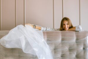 A woman with bubble unwrapping her bed 