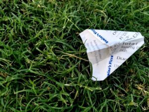 Tax receipt as a paper airplane in grass