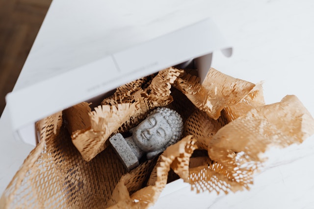 Buddha in a cardboard box before additional moving services