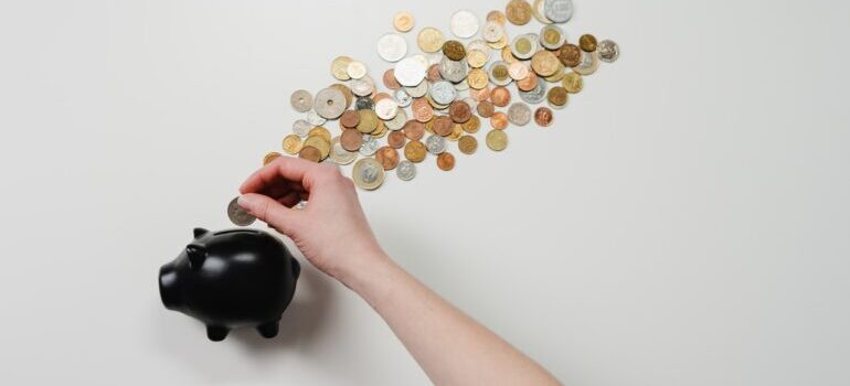 A person putting a coin in the piggy bank