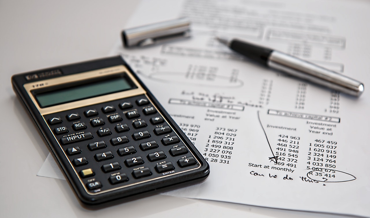 A calculator, a pen, and a paper on which long distance movers calculate costs