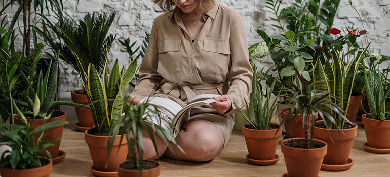 woman sitting surrounded by plants
