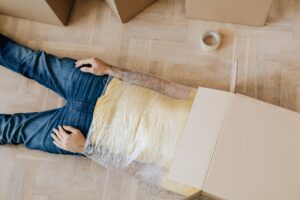 Man with head in box and wrapped body on floor