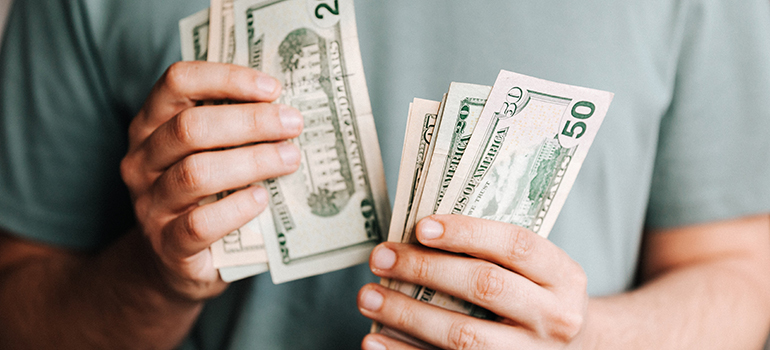 man counting money that he needs to pay the movers with