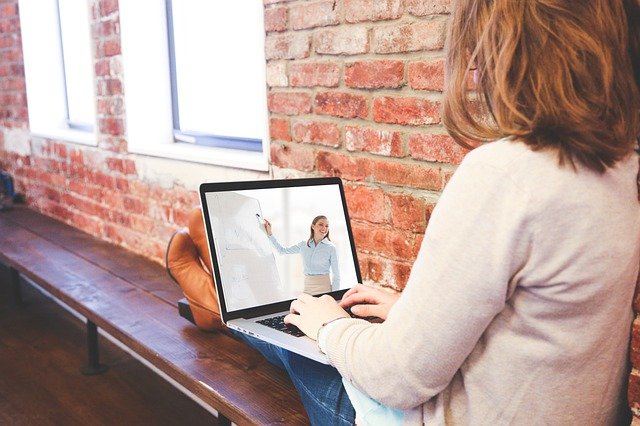 women talking over laptop