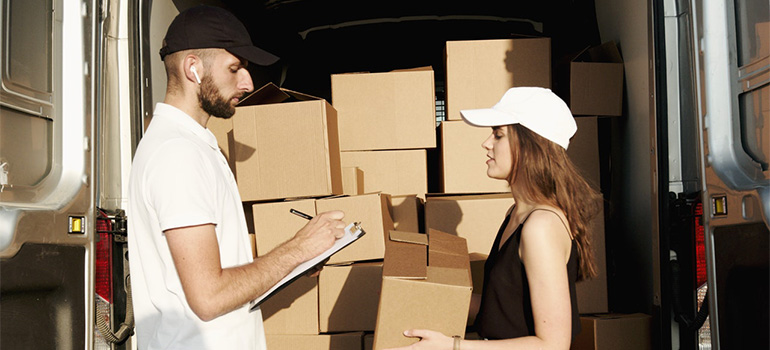 A man taking a box from a woman for shipping