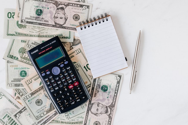 Calculator on a table next to the pile of money