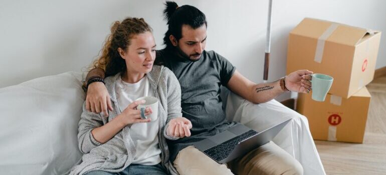 couple looking for moving companies to help them with moving from Oklahoma to Texas on their laptop