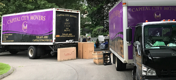 capital city movers trucks and boxes in a driveway