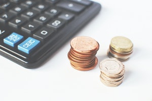 Gold coloured coins near black calculator