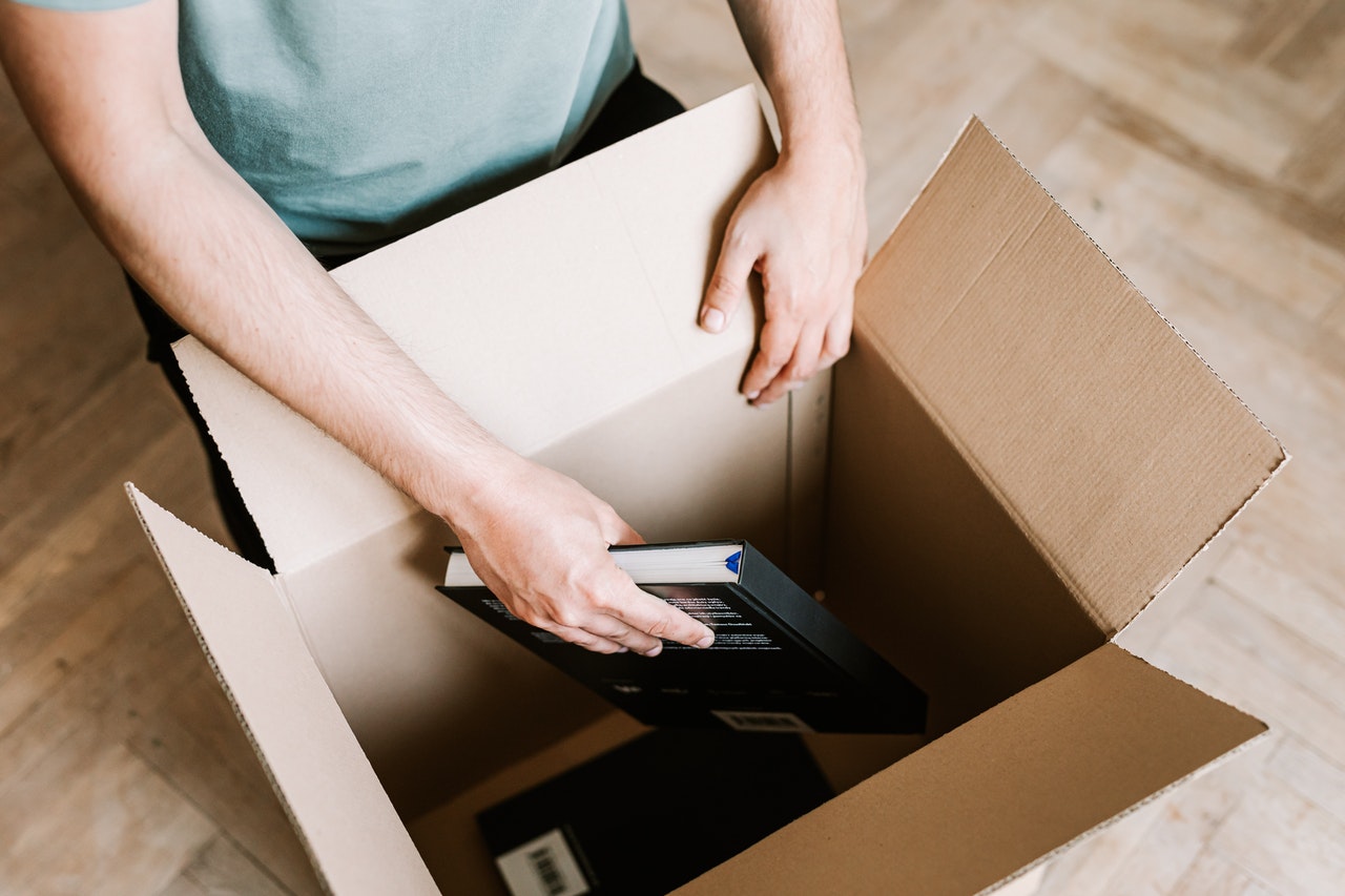 Person packing books in a box