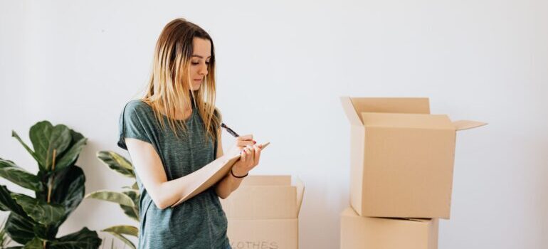 A woman writing down notes while packing