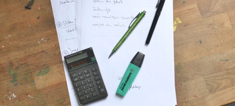 papers, pens and a calculator on the table