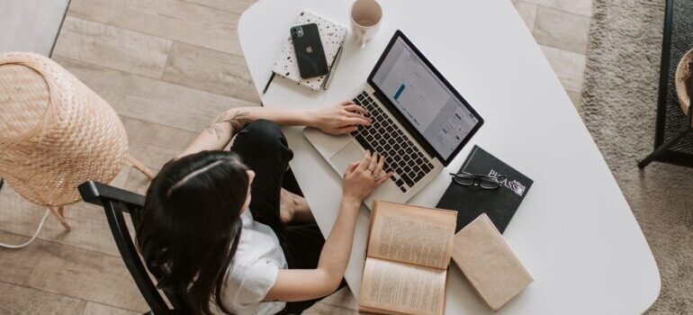 woman doing research on moving from Little Rock to Dallas TX on a laptop