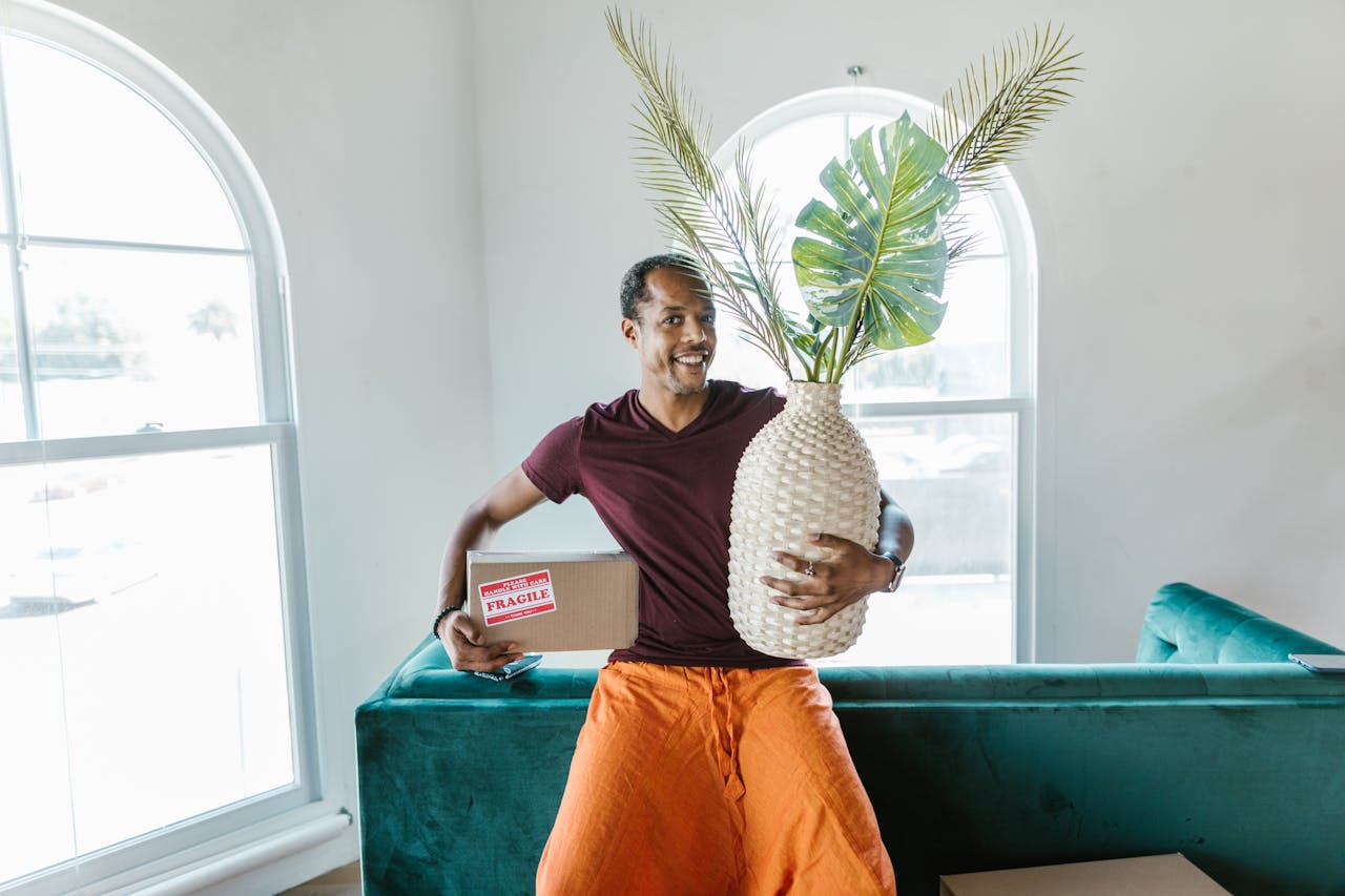 man holding a box and a vase