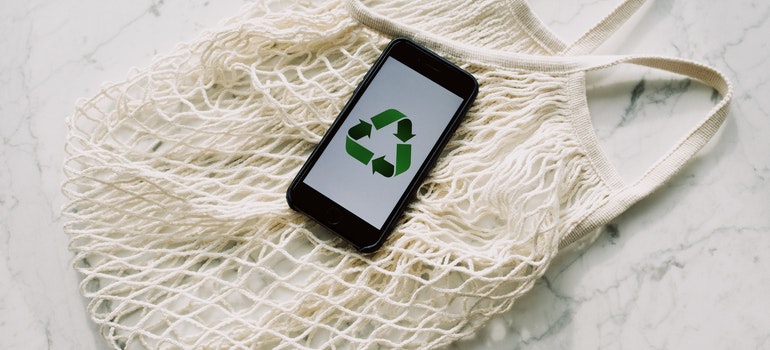 Recycle sign on phone wallpaper and mesh bag