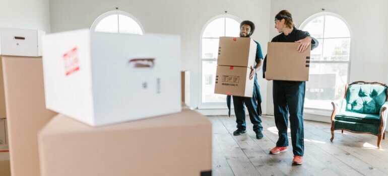 Two men holding cardboard boxes