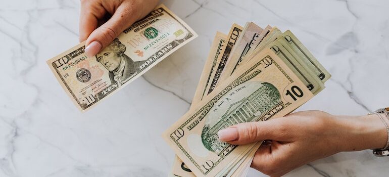 hands counting money is important when looking for cross country movers Plymouth