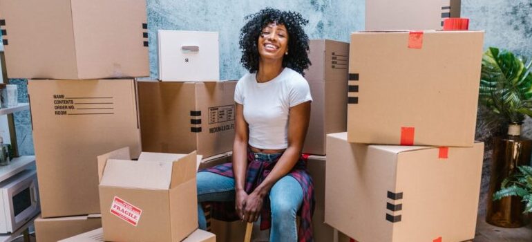 person sitting amidst cardboard moving boxes