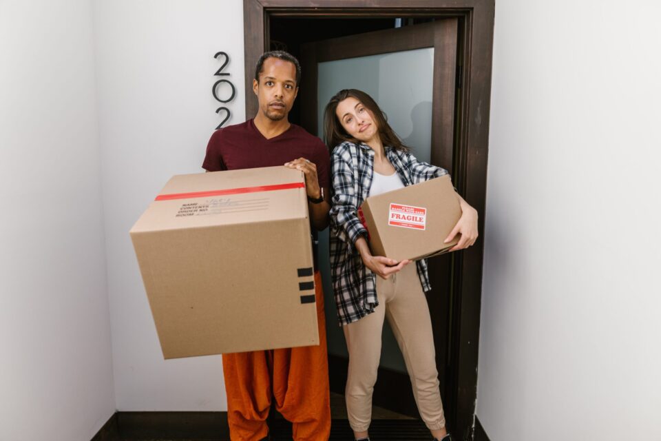 a couple holding cardboard boxes