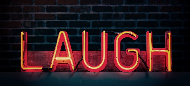 Neon “laugh” sign on black background