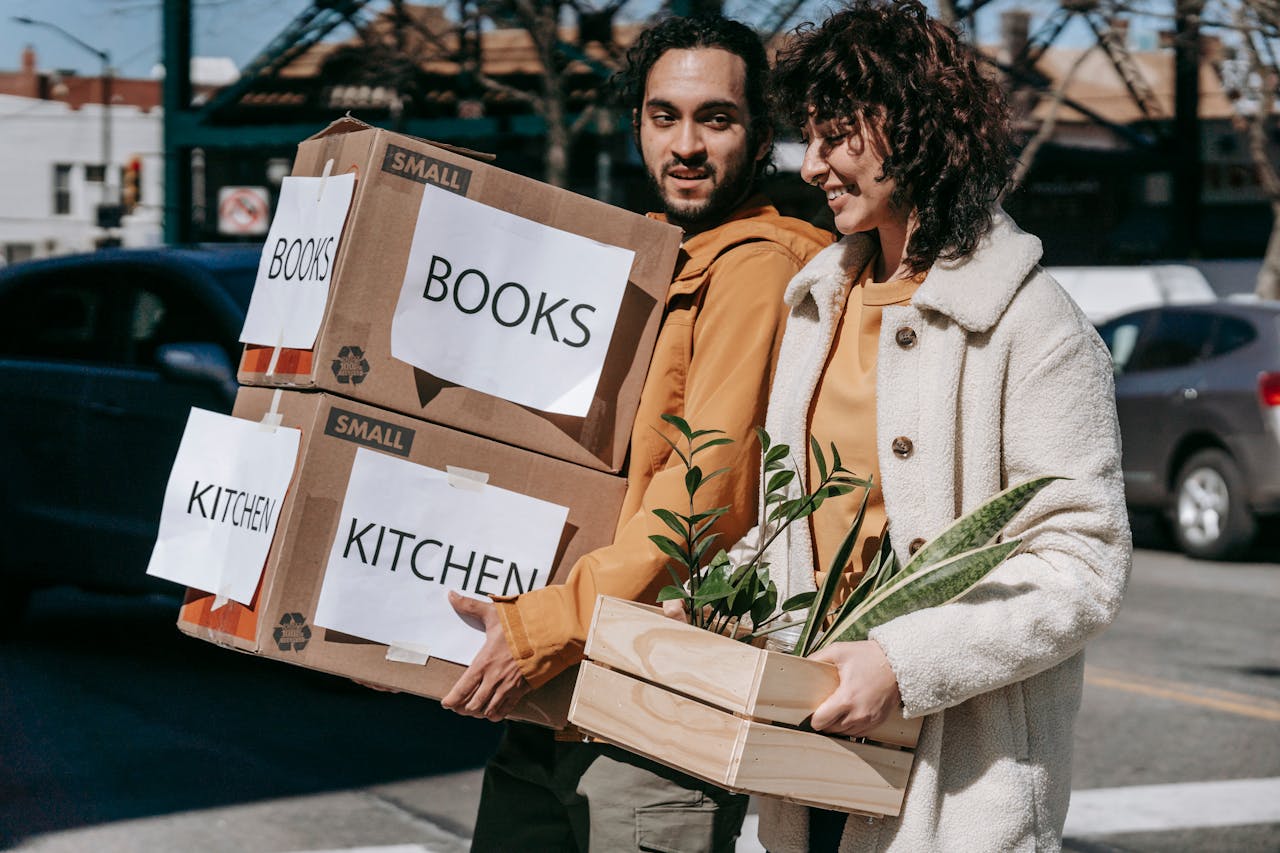 a couple carrying boxes for moving from Miami to NYC