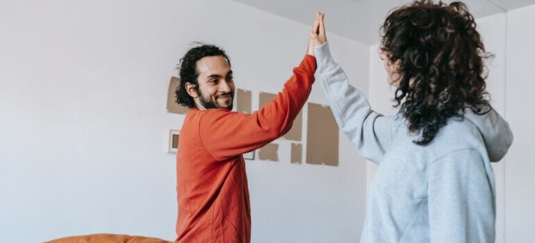 Couple doing high five after successful moving from New Jersey to Texas