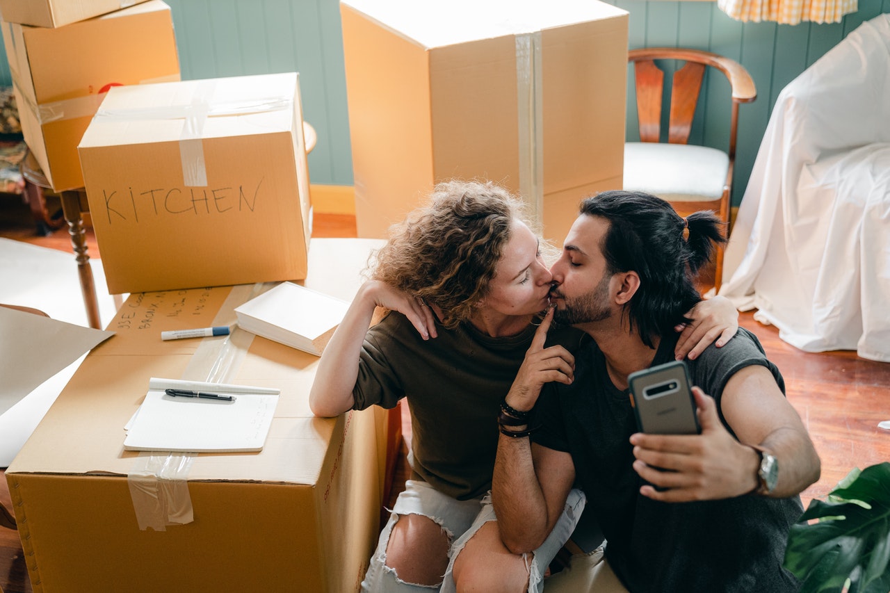 A happy couple kissing in their new home after moving from Los Angeles to Baltimore.
