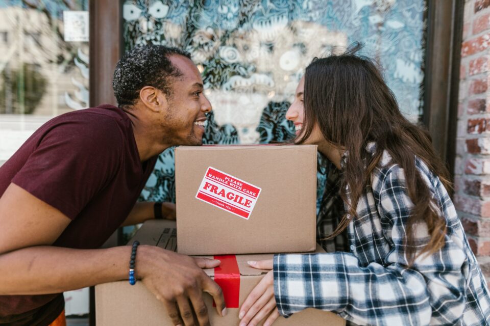 couple looking at each other over a moving box