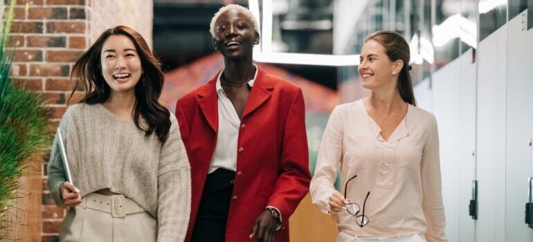 Three women walking and smiling after moving from NYC to Miami.